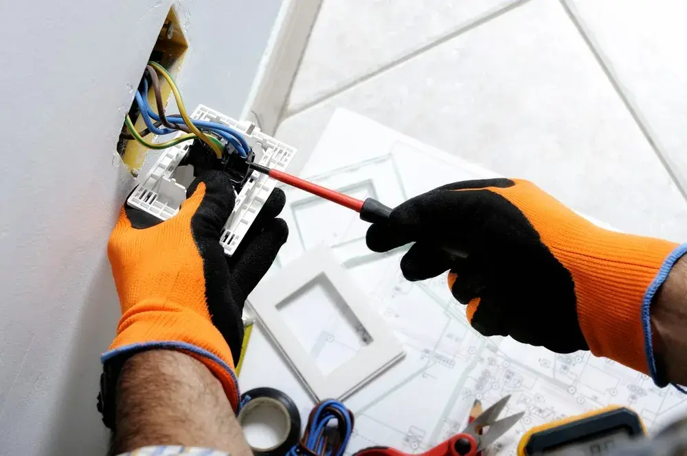 Profissional instalando tomada e fiação elétrica