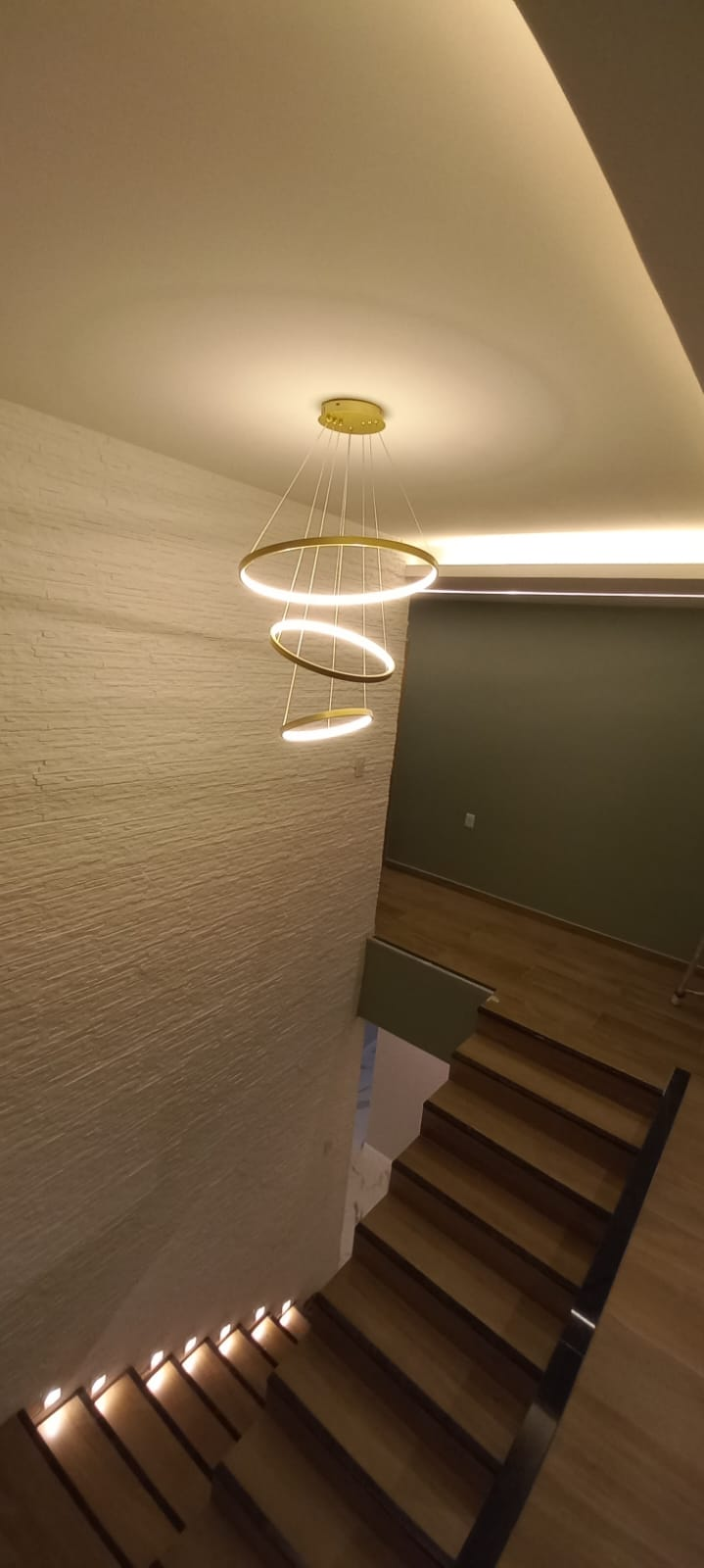 Escada com iluminação de degraus e lustre